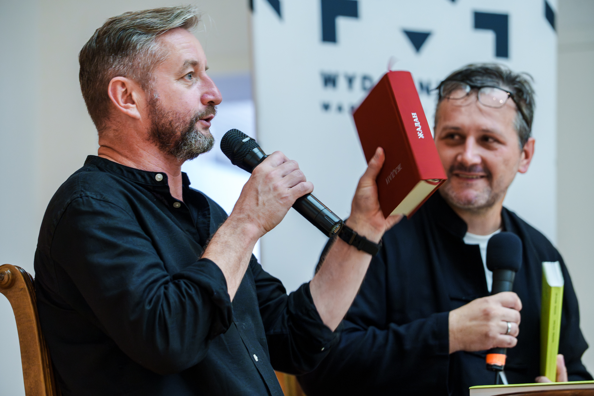 fot. Marcin Butryn (29) Autor trzyma książkę i pokazuje ją publiczności.
