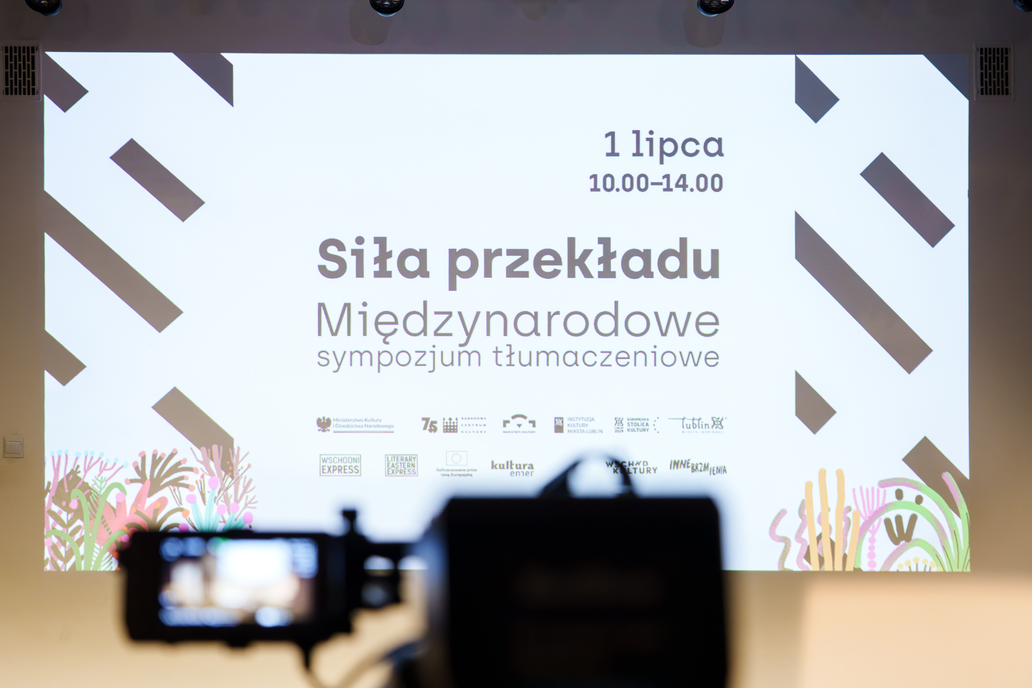 fot. Marcin Butryn (26) Na ekranie jest napisane Międzynarodowe sympozjum tłumaczeniowe „Siła przekładu”